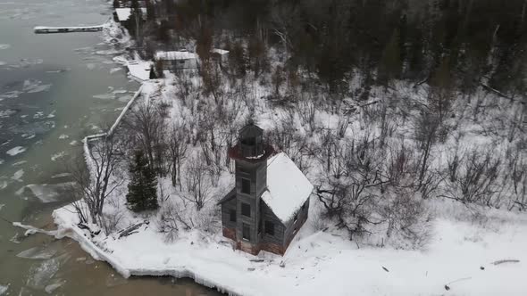 Drone view of Grand Island East Chanel Lighthouse during winter in Munising, Michigan.