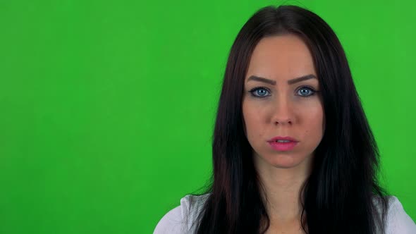 Young Pretty Woman Looks To Camera with Serious Face - Green Screen - Studio