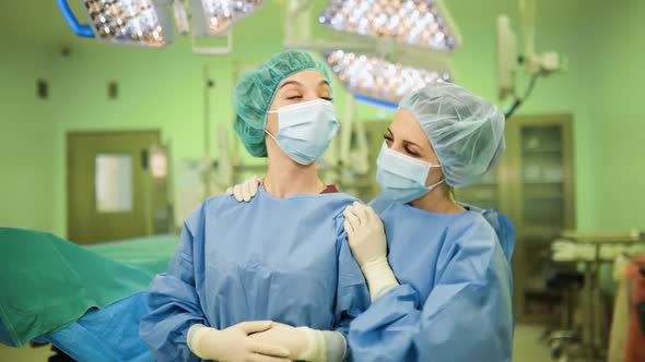 Happt Female Doctors After Successful Operation in Medical Face Masks, Gloves and Caps in Surgery