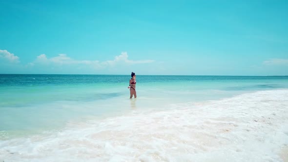 Attractive Girl Wearing Red Swimsuit On White Sand Beach With Splashing Waves In Kenyan Coast, Afric