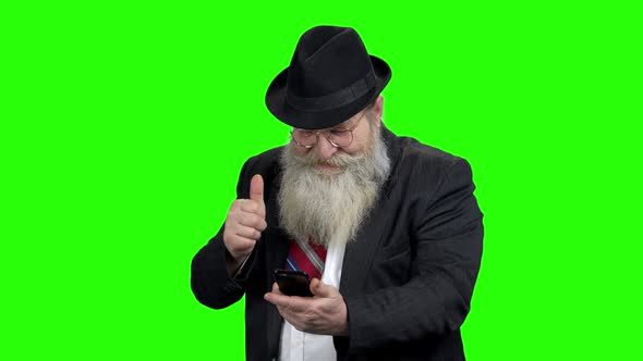 Senior Man Looking at Phone and Showing Thumb Up