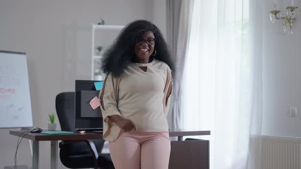 Joyful African American Young Woman Dancing in Slow Motion in Office Indoors Smiling