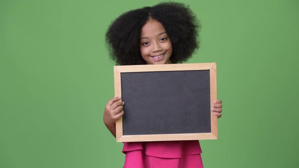 Young Cute African Girl with Afro Hair Holding Blackboard