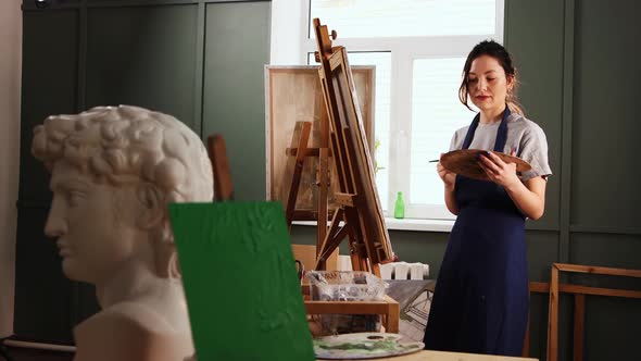 Art Studio  Young Woman Drawing a Painting on Canvas