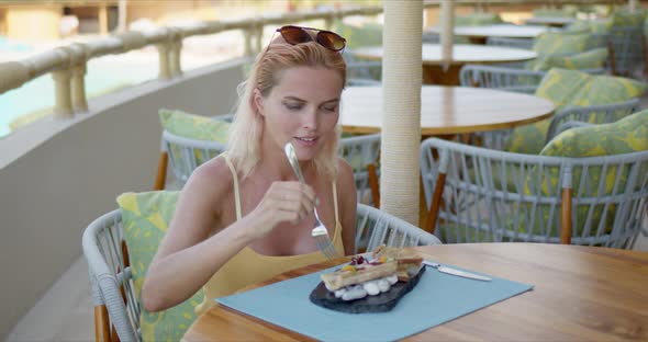 Happy Woman Enjoying Tropical Dish in Restaurant