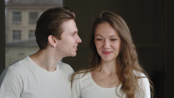 Caucasian Young Married Couple Lovers of Millennials Stand Together Indoors Boyfriend Kissing