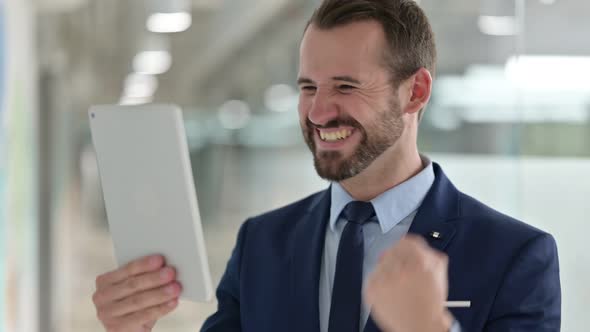 Portrait of Excited Businessman Celebrating Success on Tablet 