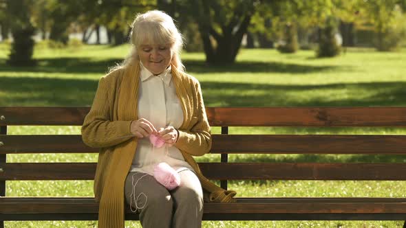 Dreamy Old Woman Knitting Little Socks for Her Granddaughter, Family Generations