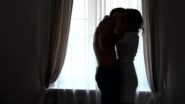 Couple Kissing Near Window.