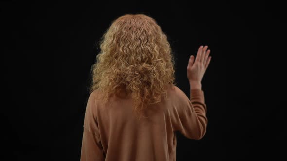 Back View of Confident Politician Woman Waving at Black Background