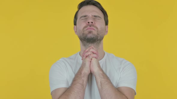 Young Man Praying to God on Yellow Screen