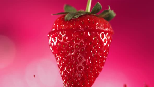 Strawberry Slice Falling and Splashing on Pink Background