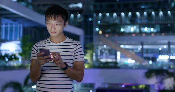 Man use of smart phone in city at night