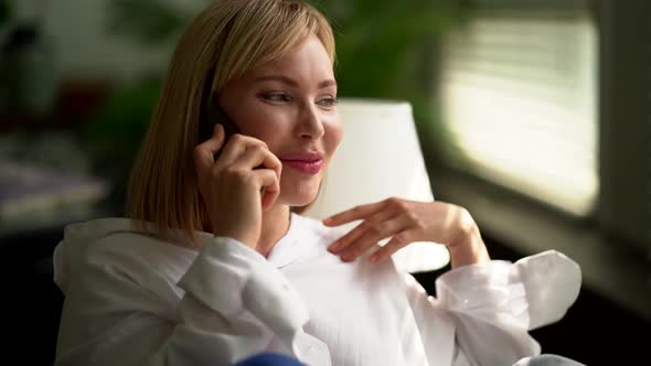 A Smiling Blonde Woman Making a Friendly Phone Call Can Talk To a Business Contact or Friend