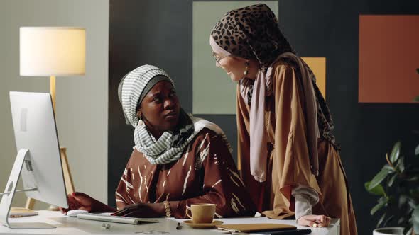 Female Muslim Colleagues Chatting in Office