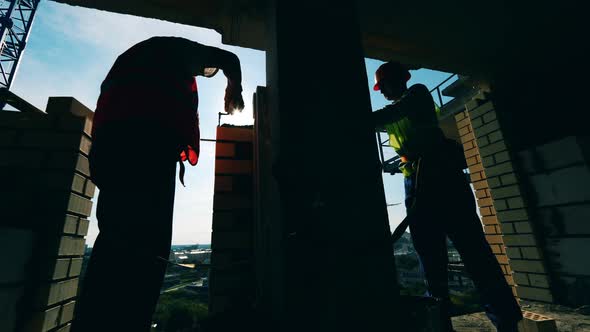 Masonry Works Held By Two Engineers in a High-rise Building