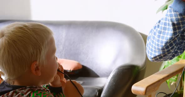 Father and children listening to music on headphones at home 4k