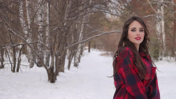 Charming Female with Long Hair Walking in Snowy Forest