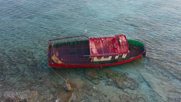 Rusty boat abandoned on shallow sea water, Kythira island Greece.