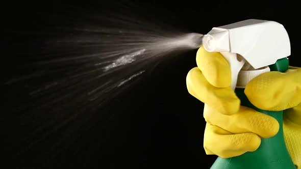 Hand in Glove Holds Spray Bottle, on Black, Slow Motion, Close Up