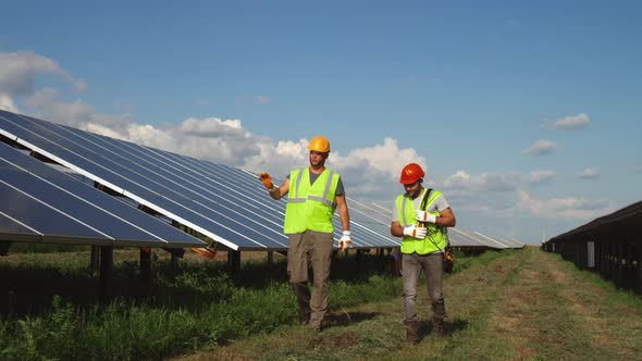 Male Colleagues Walking and Talking on Solar Farm
