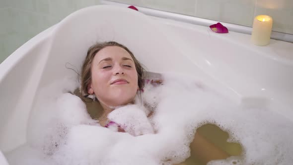 Young Slim Caucasian Woman Diving in Bathtub Water in Slow Motion