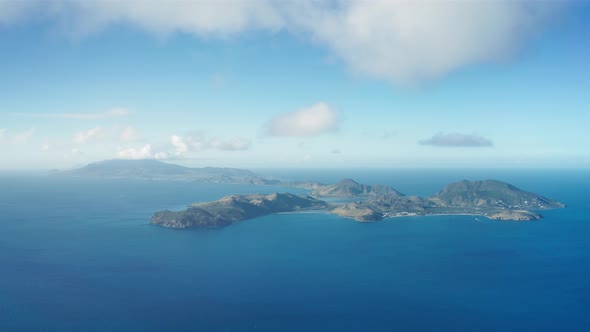 Aerial shot of mountainous islands surrounded by endless blue sea in Saint Kitts and Nevis
