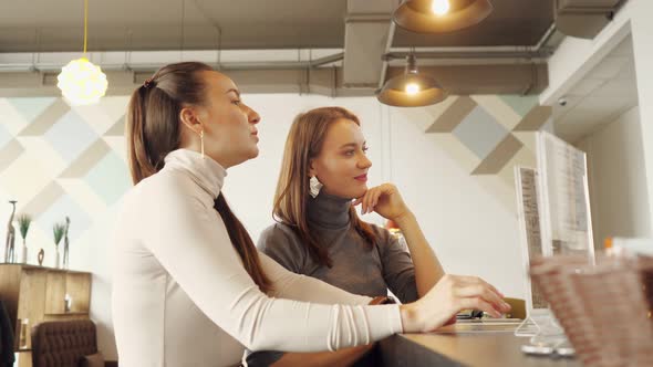 Two Women Discuss the Menu and Choose Food in a Cafe Standing at the Bar Counter.