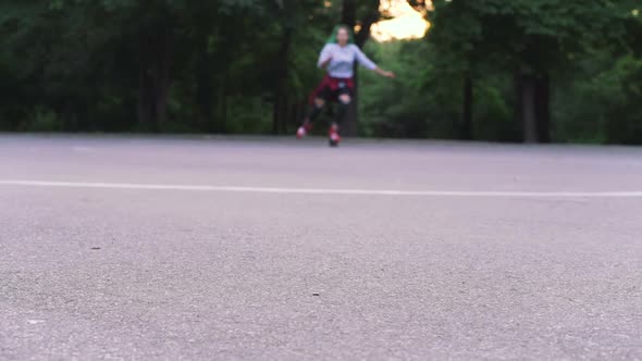 Young Stylish Funky Girl with Green Hair Riding Roller Skates and Dancing in Park Slow Motion