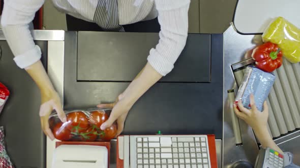 Zoom Out of Hands of Cashier Scanning Products