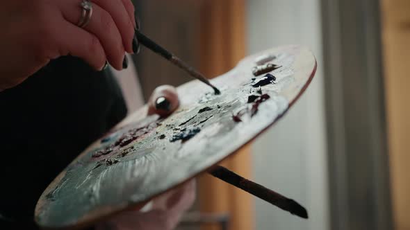 Close Up of Unrecognizable Female Artist Mixing Dyes on Palette Making Color for Artwork at Studio