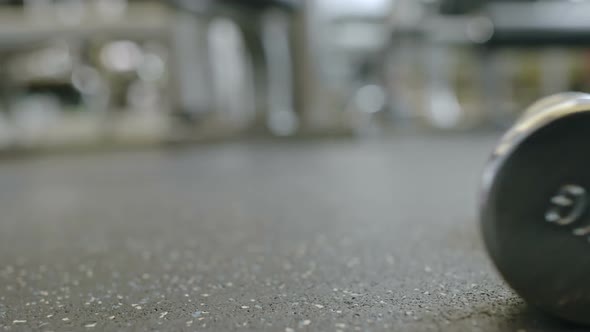 Dumbbell Rolling Across Gym Floor