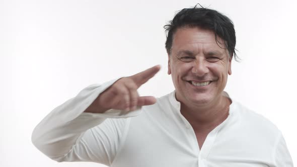 Closeup of Happy Middleaged Man in Casual White Shirt Smiling Saluting you Standing Over White