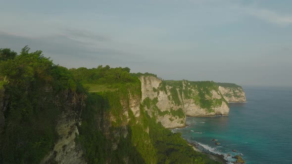Tropical limestone cliffs of Nusa Penida with blue sea water, aerial