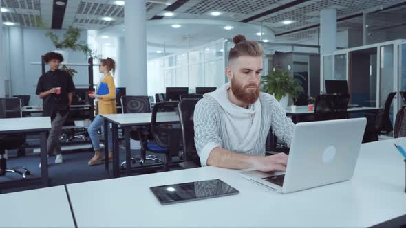 Hipster Employee Working on Laptop in Office