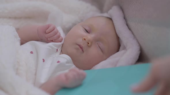 Closeup Portrait Sleeping Little Baby Girl Lying in Bed with Female Hand Trying Take Tablet