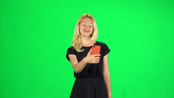 Girl Tourist Goes and Takes a Selfie, Then Looks Through the Photos on the Smartphone. Chroma Key