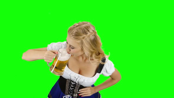 Woman in Bavarian Costume Drinks a Little of Beer of Glass. Green Screen
