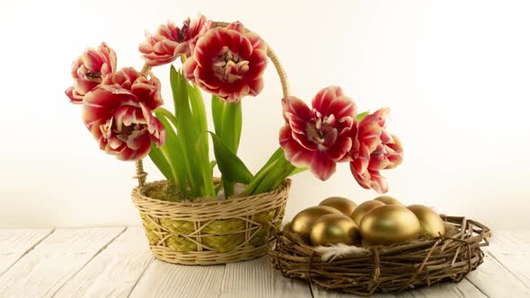 Beautiful Bouquet of Red Tulips Flowers in a Basket and with Easter Golden Eggs in the Nest on a