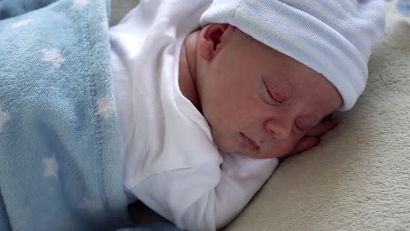 Closeup Newborn Baby Face Portrait Early Days Sleeping Sweetly On Tummy Blue White Background