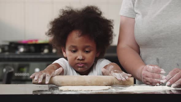 Black Little Girl Rolling Out the Dough in the Bright Kitchen