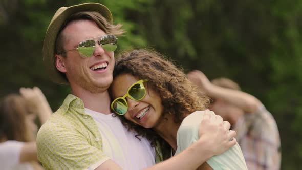 Cheerful Girl Cuddling With Boyfriend, Young Couple Dancing at Summer Party