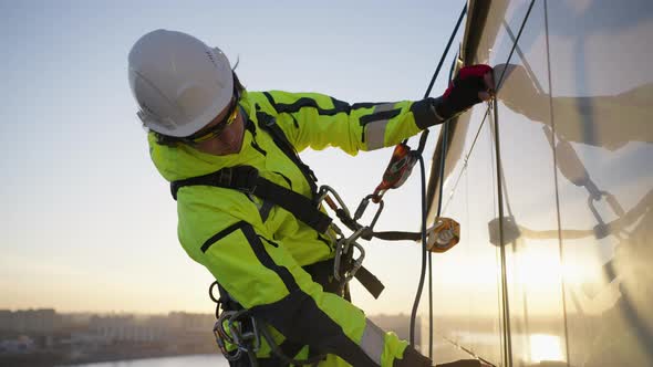 Industrial Climber Makes Measurements of Tile on Building