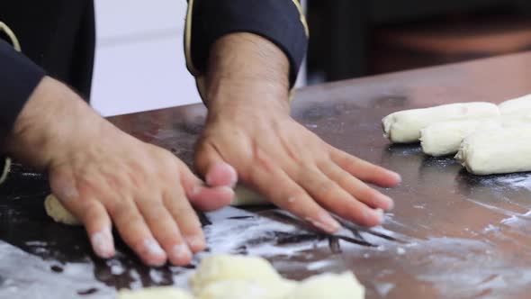 An Experienced Chef in a Professional Kitchen Prepares the Dough  with Flour