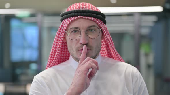 Middle Aged Arab Man Putting Finger on Lips