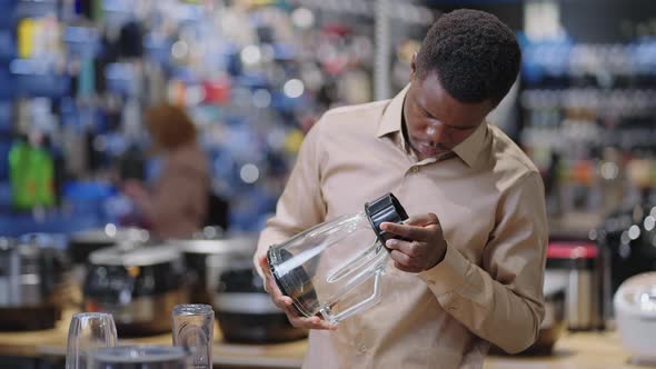 Young Black Man is Viewing Blender in Home Appliances Store Choosing Equipment for Kitchen Medium