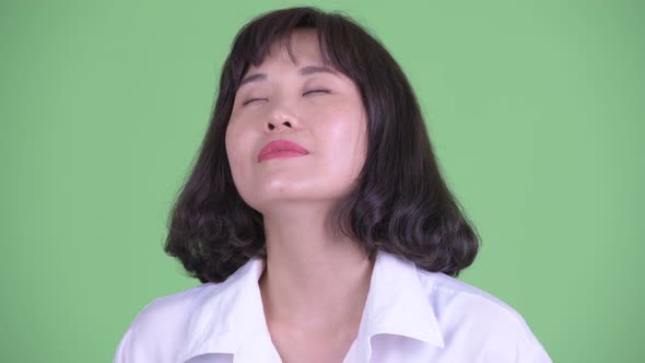 Face of Happy Beautiful Asian Businesswoman Relaxing with Eyes Closed