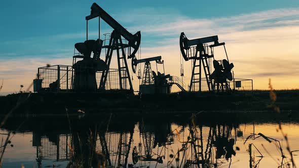 Silhouettes of Working Oil Pump Jacks at Sunset