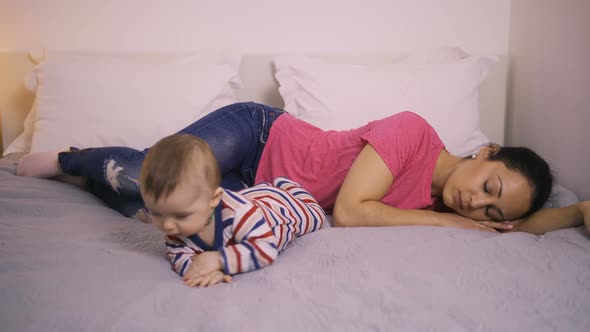 Depressed Mother on Bed with Baby and Staring Away