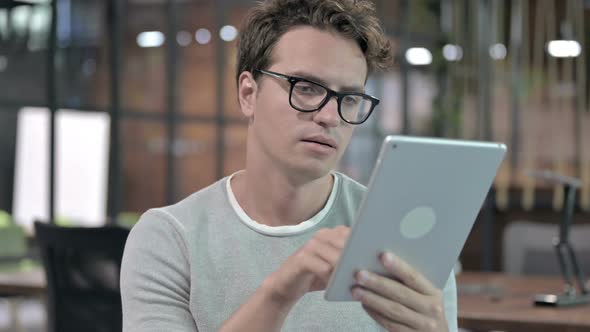 Portrait Shoot of Handsome Guy Scrolling on Tablet